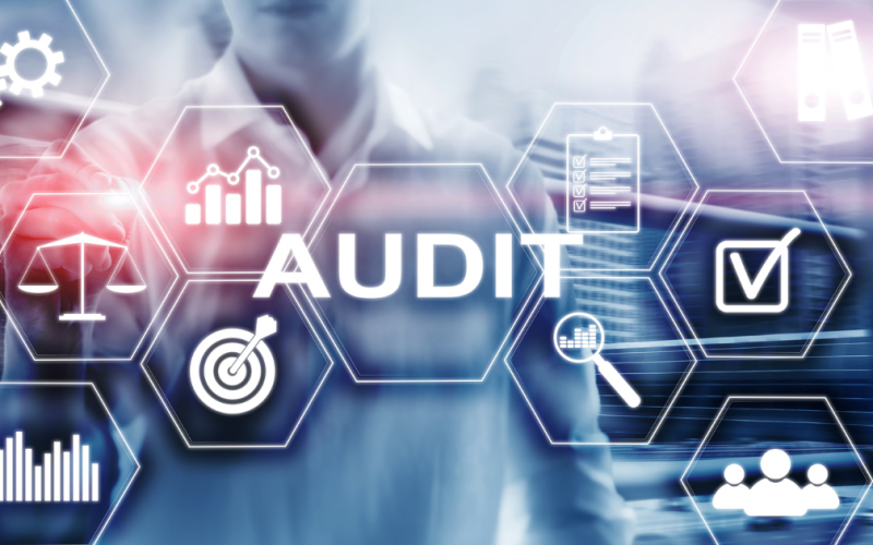 Some machinery on a blue background overlaid with the word audit.